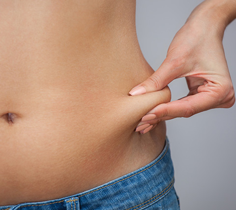 Mujer que toca su grasa abdominal, lipoescultura en Bogot